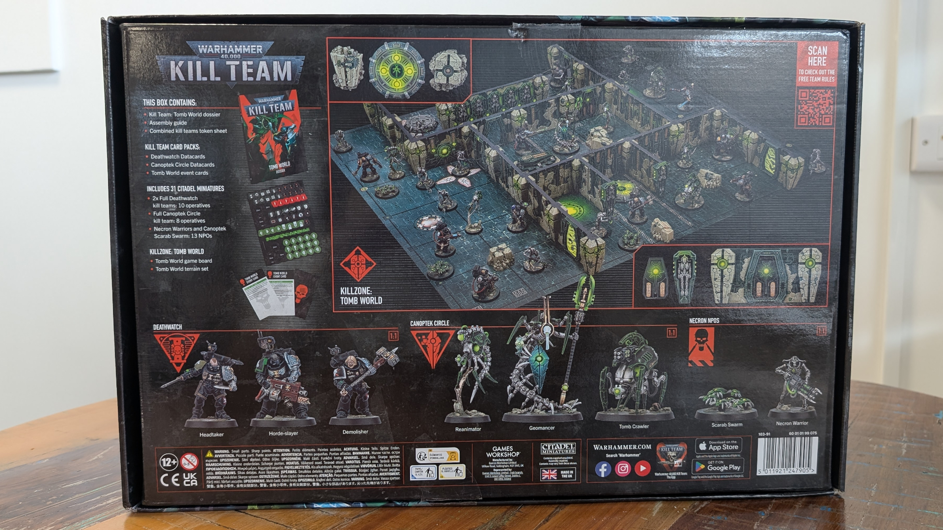 The back of the Kill Team: Tomb World box, on a wooden table