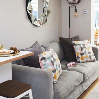 living room with grey wall and grey sofa with cushion