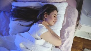 Woman holding her neck in pain while she sleeps on her side