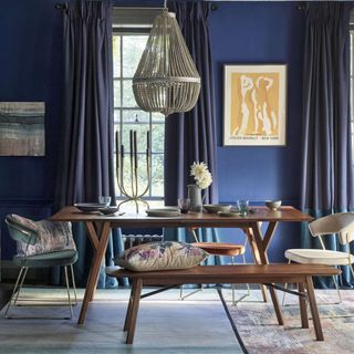 blue walls with blue curtains dinning table and chandelier