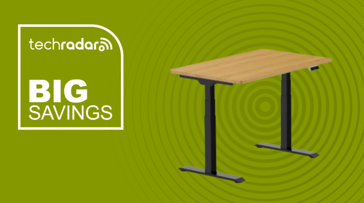 FlexiSpot E7 standing desk on a green background with a TechRadar badge reading 'Big Savings'