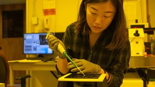A shot of a Caltech student working in their nano-fabrication lab.
