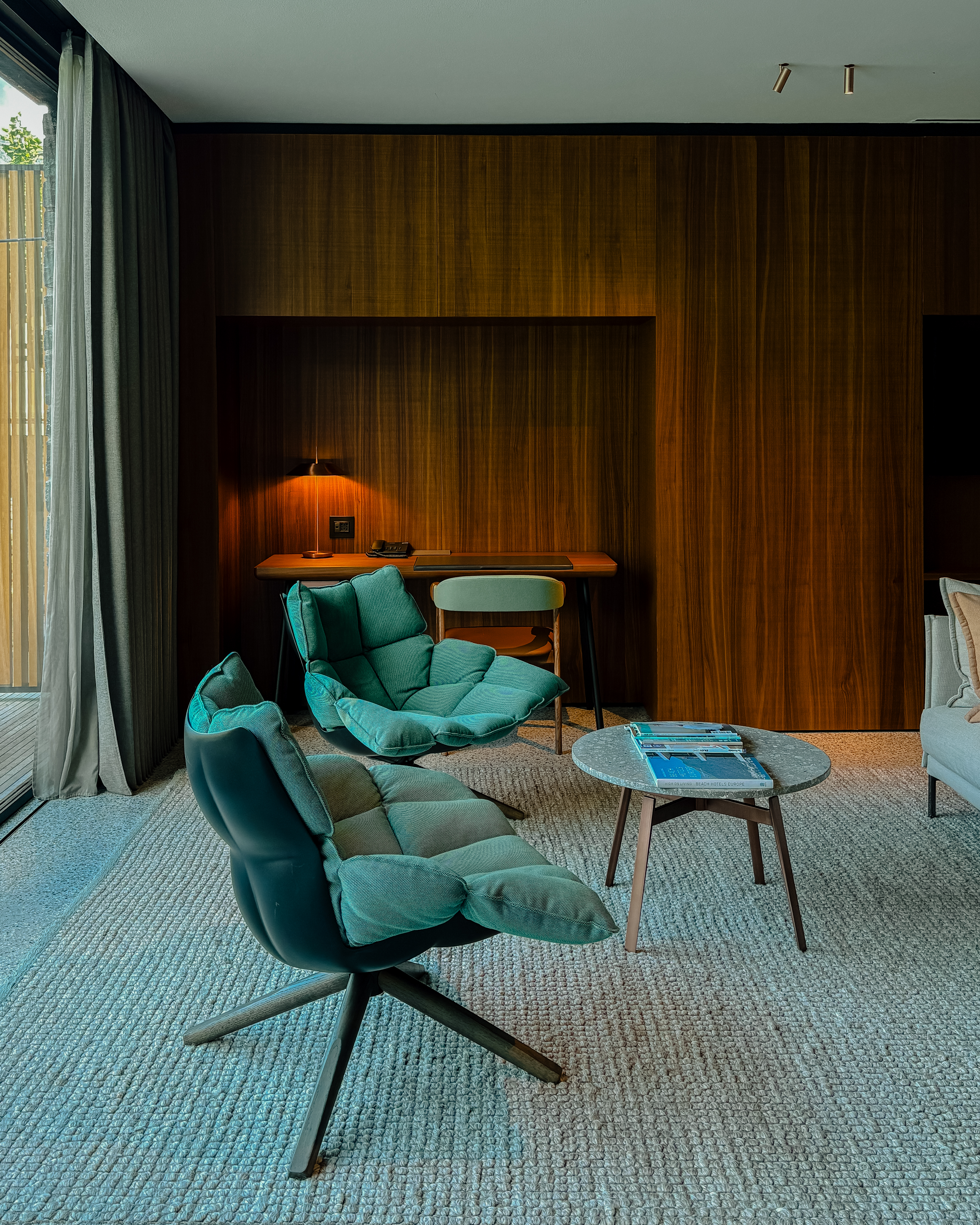A mid-century modern-inspired hotel suite features earthy-tinted interiors, colorful design collectibles, and plenty of music equipment.