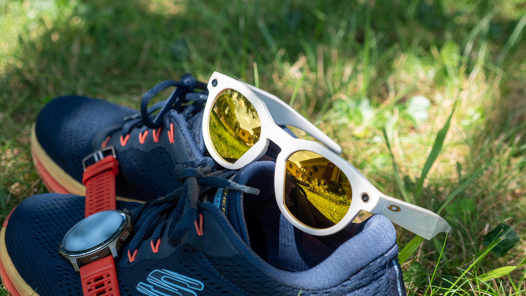 A pair of warm white limited edition Oakley Meta HSTN smart glasses with PRIZM lenses with running shoes and an Amazfit Balance 2 smartwatch