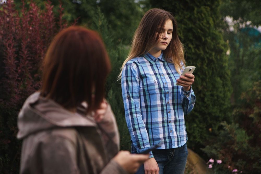 Teenage Girl Being Bullied By Text Message On Mobile Phone