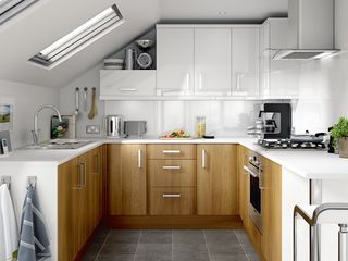 small kitchen in an awkward space under eaves with wood finish and white cabinets