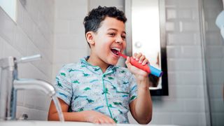 Boy uses one of the best electric toothbruhshes for kids