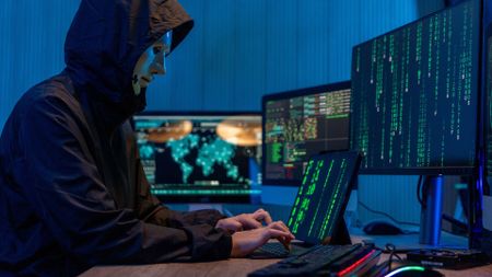 a scammer typing on a computer