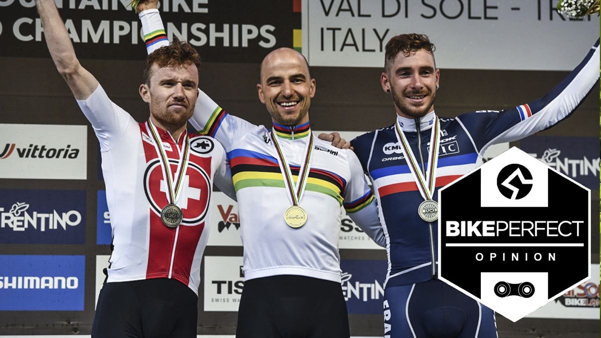 Mathias Flueckiger, Nino Schurter, Victor Koretzky stand on the podium wearing their medals with their hands in the air