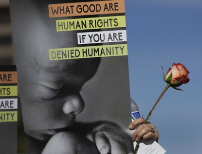A pro-life protester holds a sign