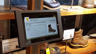 The footwear department and high-visibility areas feature two Microsoft Surface Pro 3 tablets with content specific to each area.