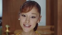 Ariana Grande smiling in the Petal music video. 
