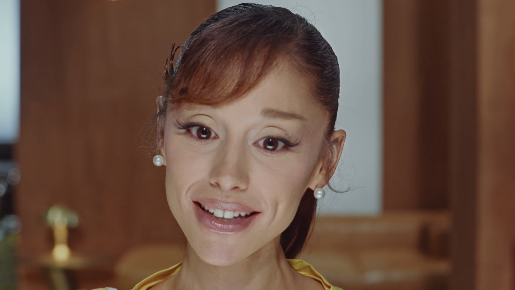 Ariana Grande smiling in the Petal music video. 
