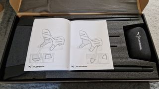 The manual and open box of the PlaySeat Puma Active gaming seat