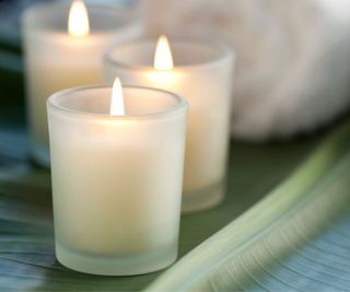 Three candles in front of a spa towel