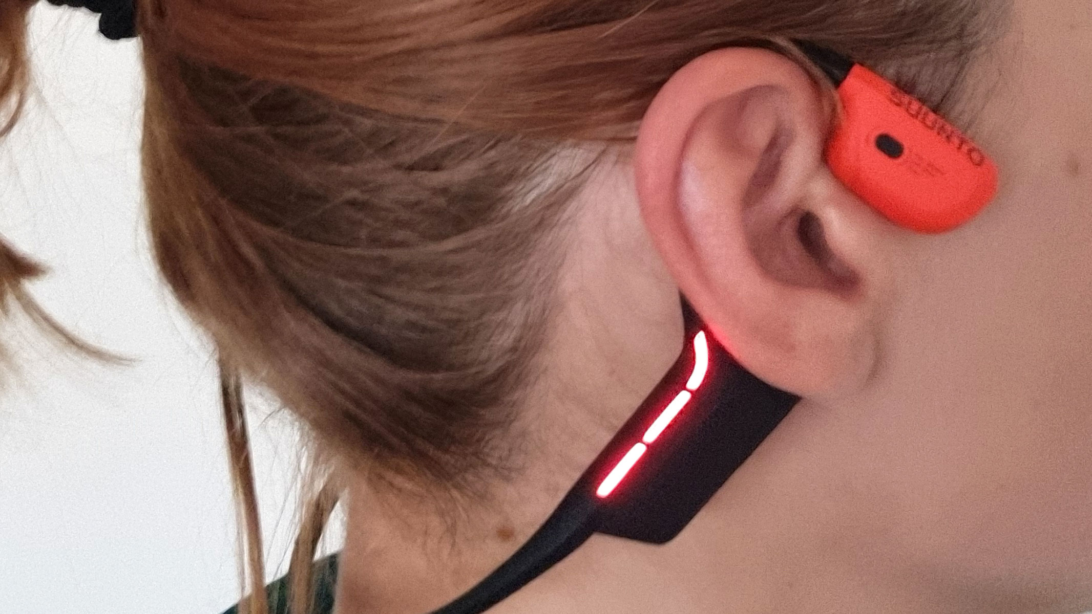 A close-up picture of our reviewer testing the Suunto Wing 2 bone conduction headphones
