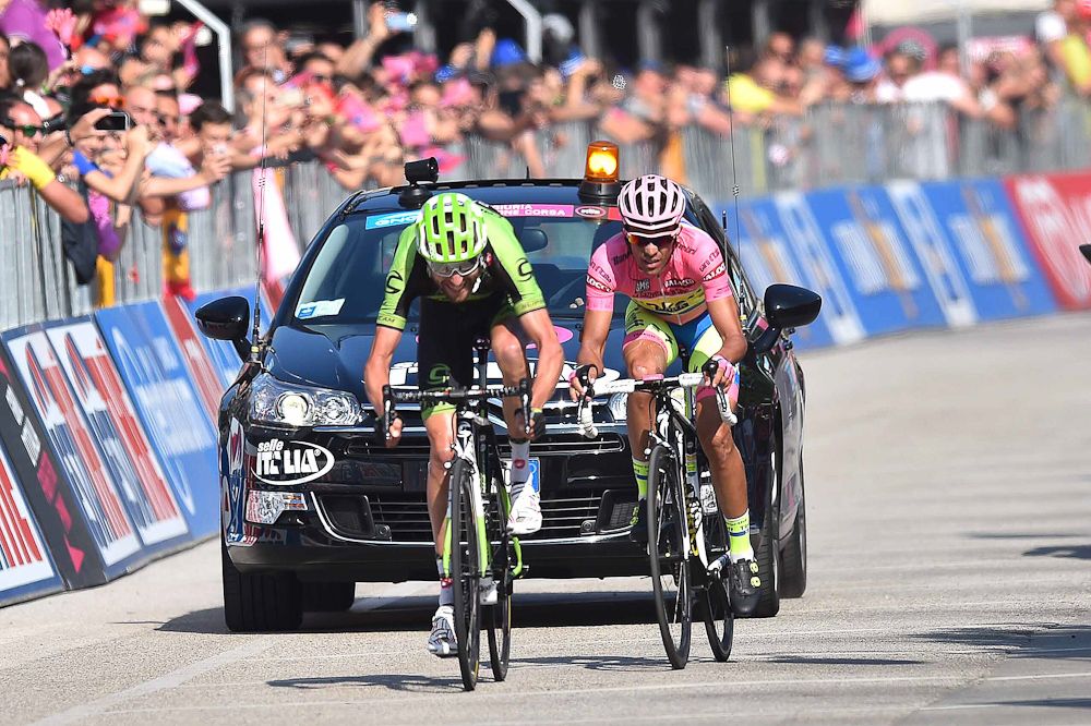 Ryder Hesjedal kicks past Alberto Contador at the finish line of stage 18.
