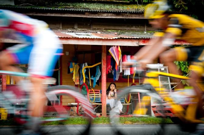 A local girl watches as the peloton race by in Langkawi