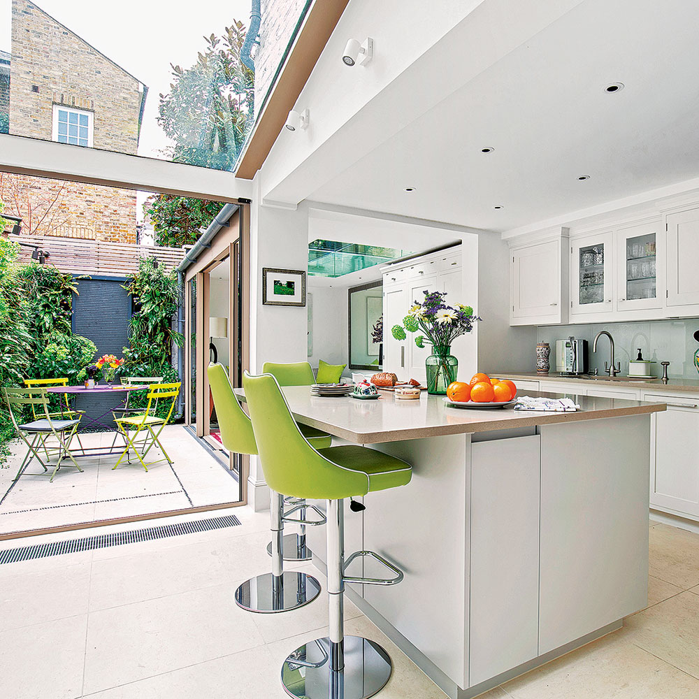 white kitchen in modern extension with island and large skylight