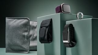 From left to right the image shows the Withings under mattress sleep tracker, Garmin Index Sleep Monitor sleep tracker, Apple Watch Series 10, the Whoop MG fitness tracker and the Oura Ring 4, all positioned on a sage green background.