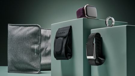 From left to right the image shows the Withings under mattress sleep tracker, Garmin Index Sleep Monitor sleep tracker, Apple Watch Series 10, the Whoop MG fitness tracker and the Oura Ring 4, all positioned on a sage green background.