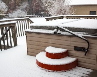 hot tub on wooden deck covered in snow