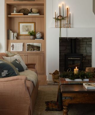 christmas decorating living room with muted colors and a fireplace with candles