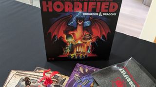Horrified: Dungeons & Dragons box against a dark surface, with game components visible in the foreground