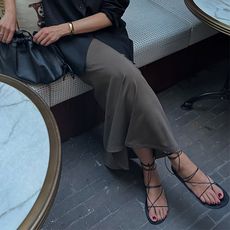 lucy wears skirt sandals and black handbag