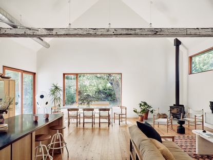 Open plan kitchen, living area and dining room with wooden flooring and a fireplace 