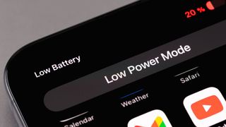 iPhone screen displaying a Low Battery notification and the Low Power Mode setting pop-up in Dark Mode