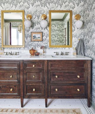 Double vanity bathroom idea with wallpapered wall and gilted mirrors over