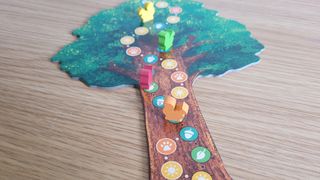 A tree board with squirrel tokens on, sat on a wooden table