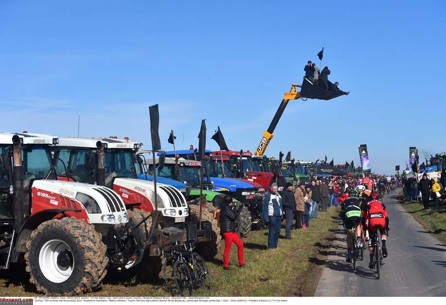 The peloton is flanked by honking tractors