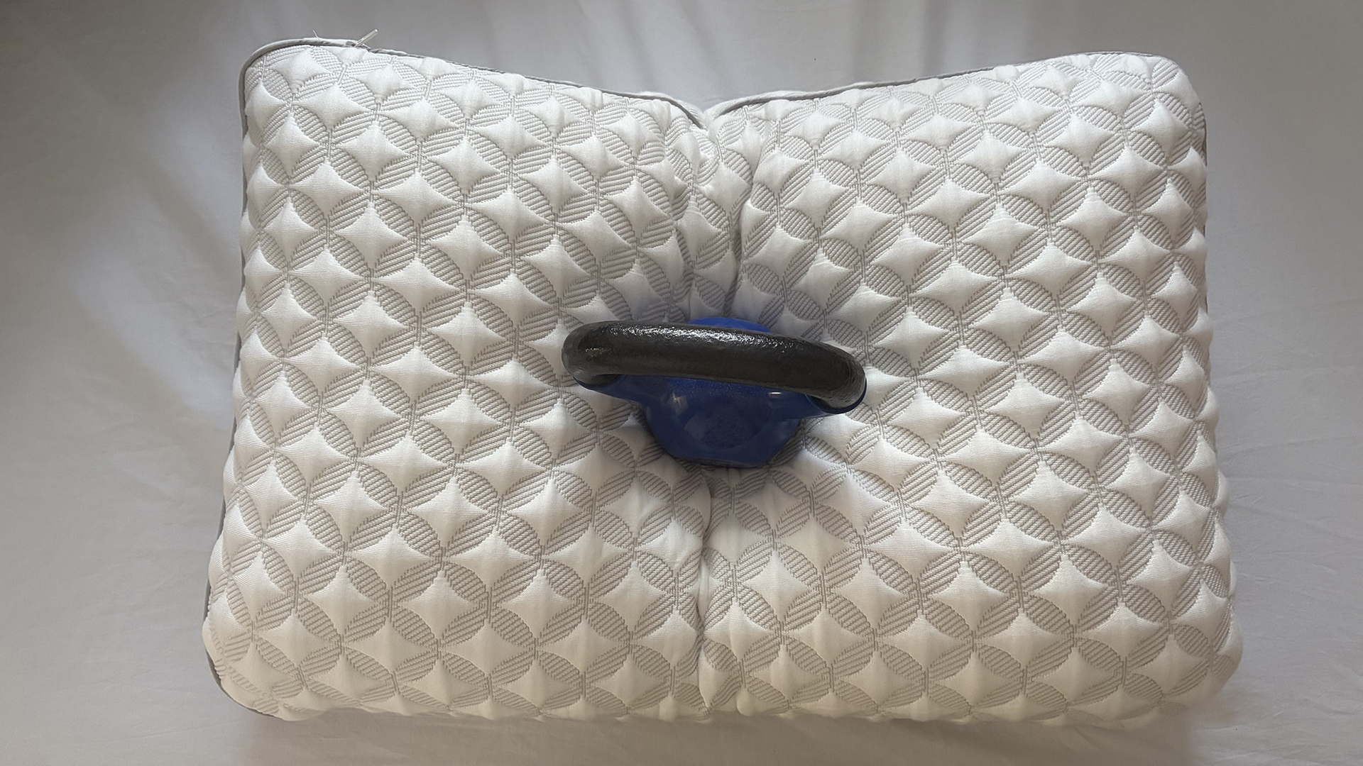 A 10lb weight resting in the middle of the Helix Talalay Latex pillow