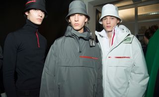Three young men modelling jackets and hats by Prada.
