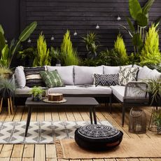 grey sofa with cushion wooden floorboard and potted plant