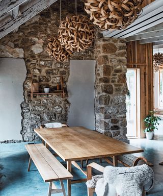 Dining area with benches in lighting designer Tom Raffield's Cornish timber home