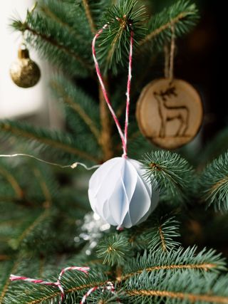 white paper decoration hanging on a Christmas tree