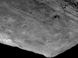 In this image of the south pole region of the asteroid Vesta, a mountain is rising approximately 9 miles (15 kilometers) above the floor of a crater.