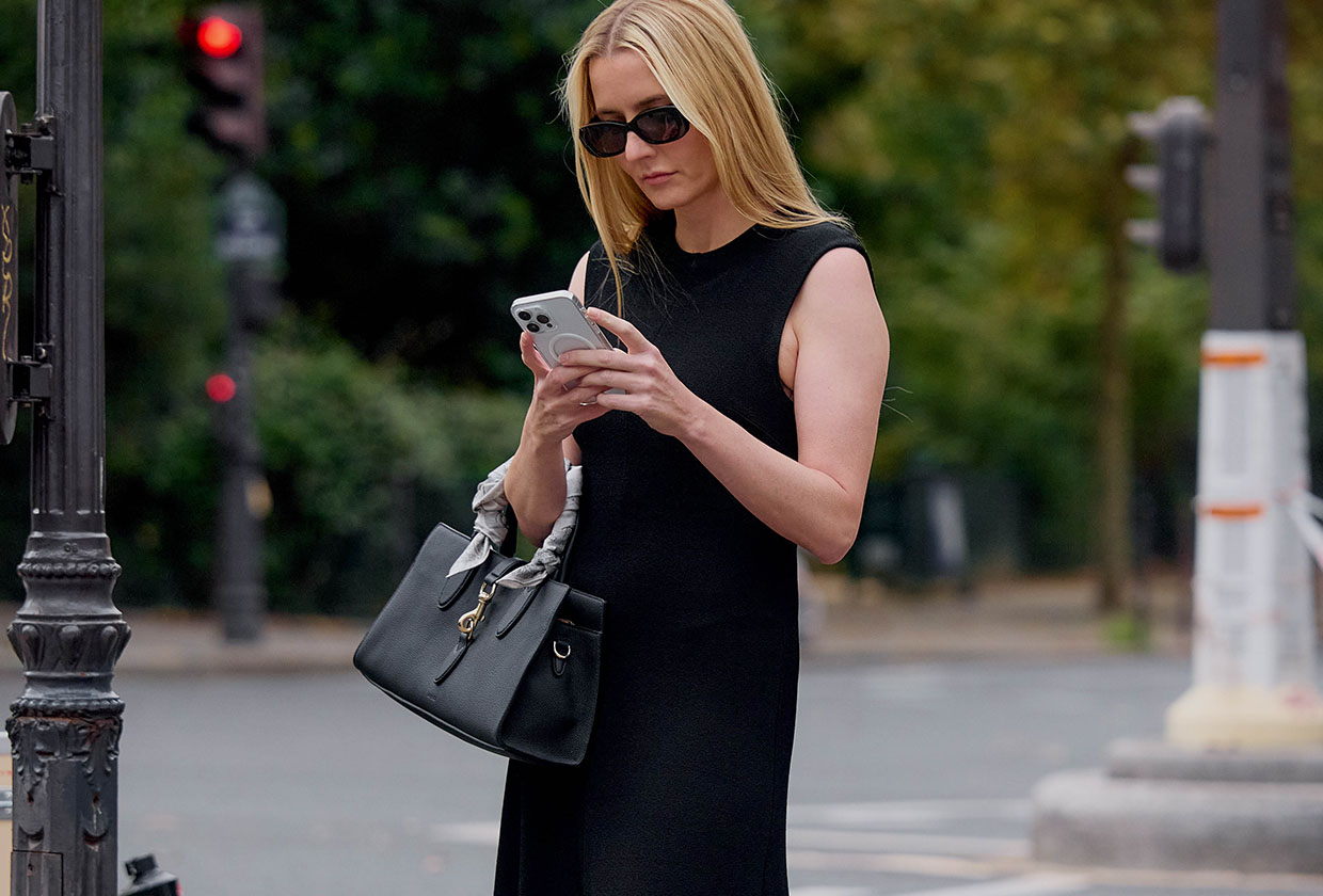 Woman in black dress looking at phone