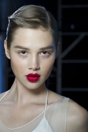 Model wearing light make-up and blood red lips