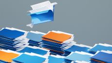 Data backup concept image showing file folder stacked up with one folder hovering above the rest.