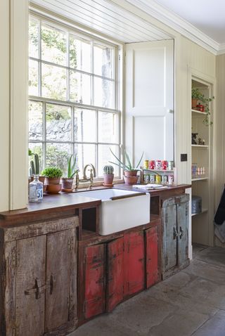 Distressed vintage cabinetry and butler's sink in country-style kitchen