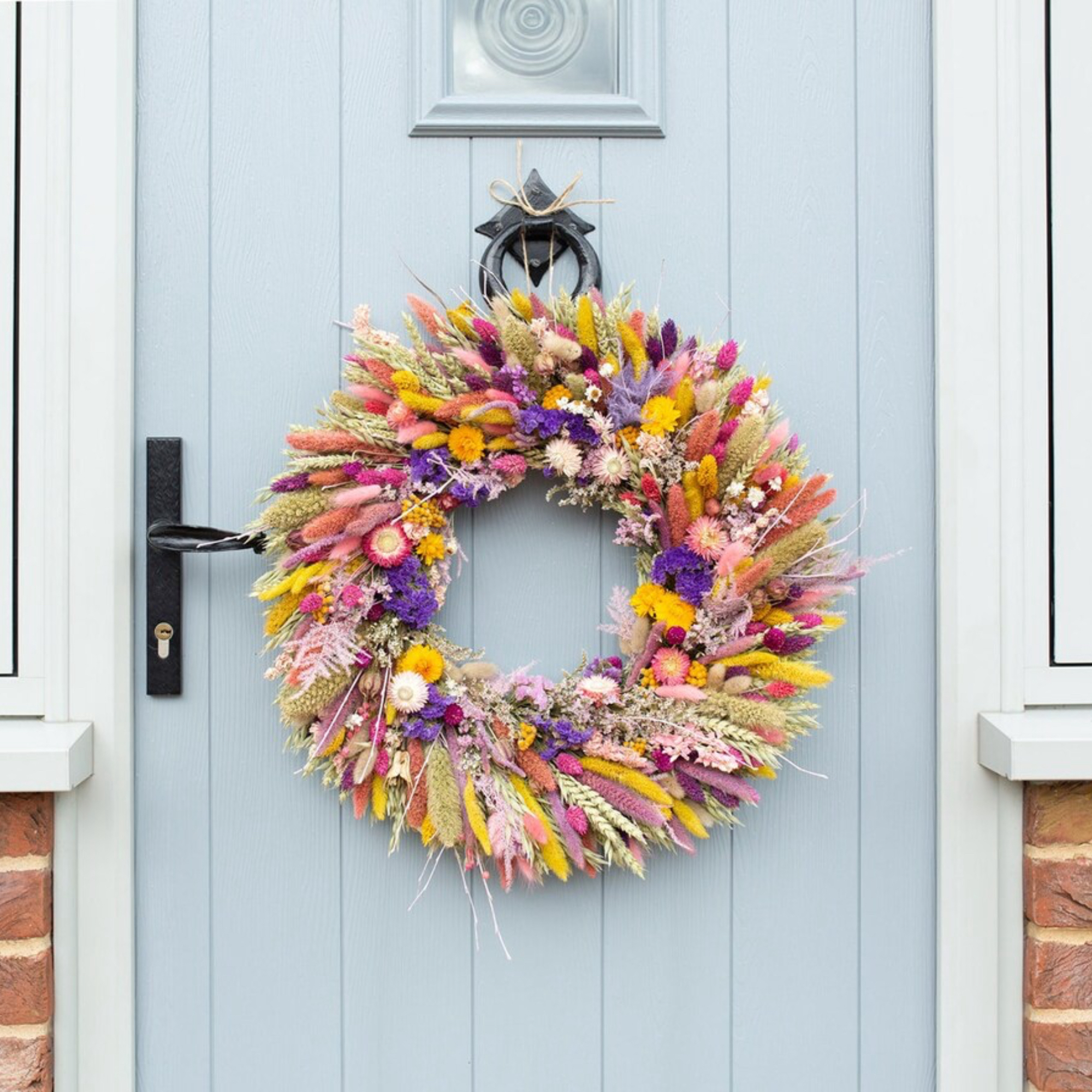 Pale blue front door with dried spring wreath