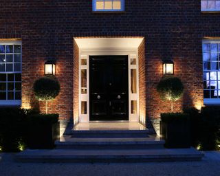 front door with lighting from John Cullen Lighting and topiary