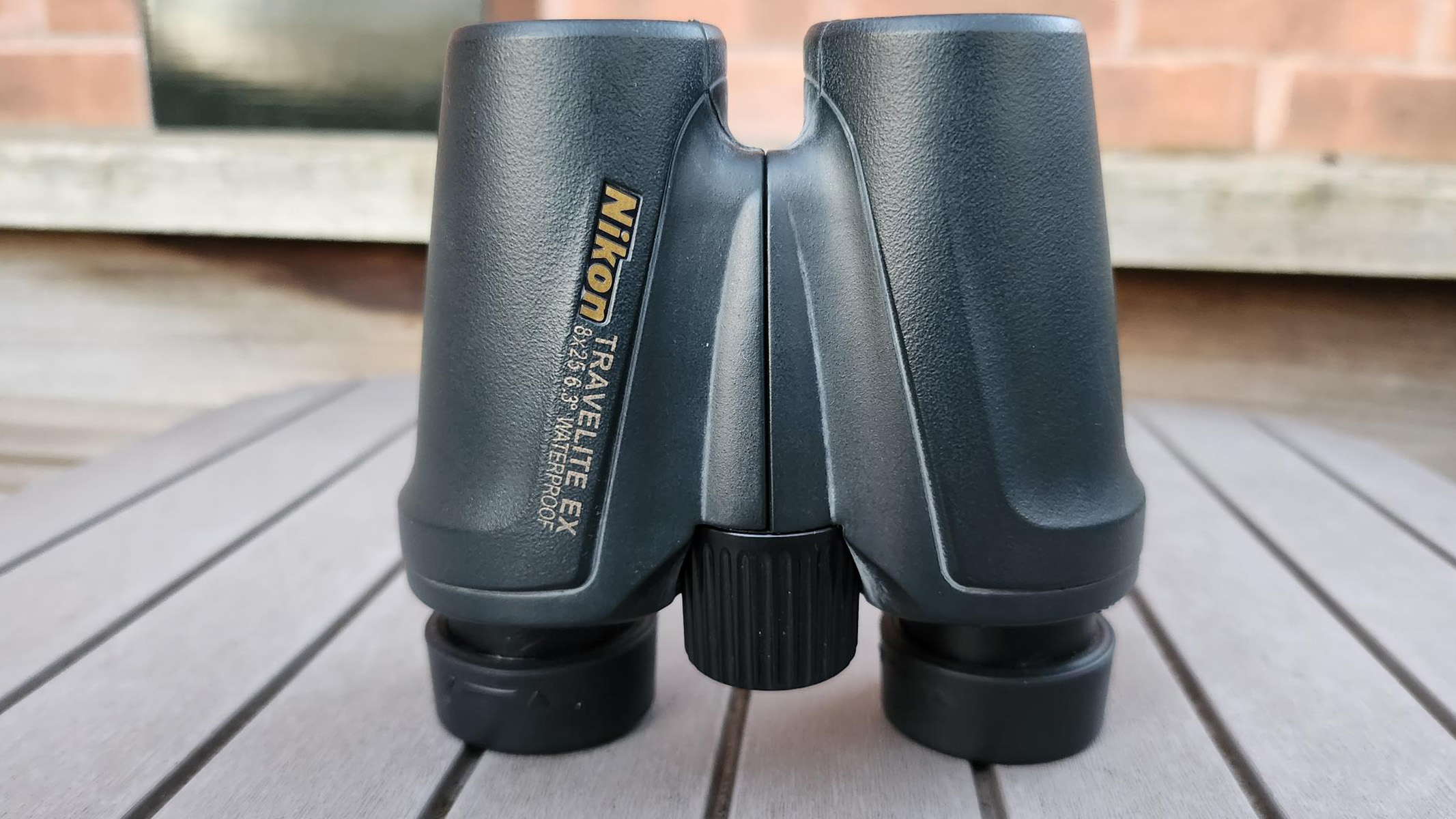 Photo shows the Nikon Travelite EX 8x25 binoculars on a table showing the central focusing dial