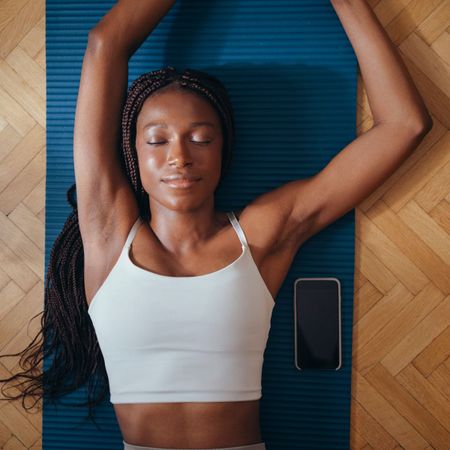 A woman stretching on a yoga mat on the floor
