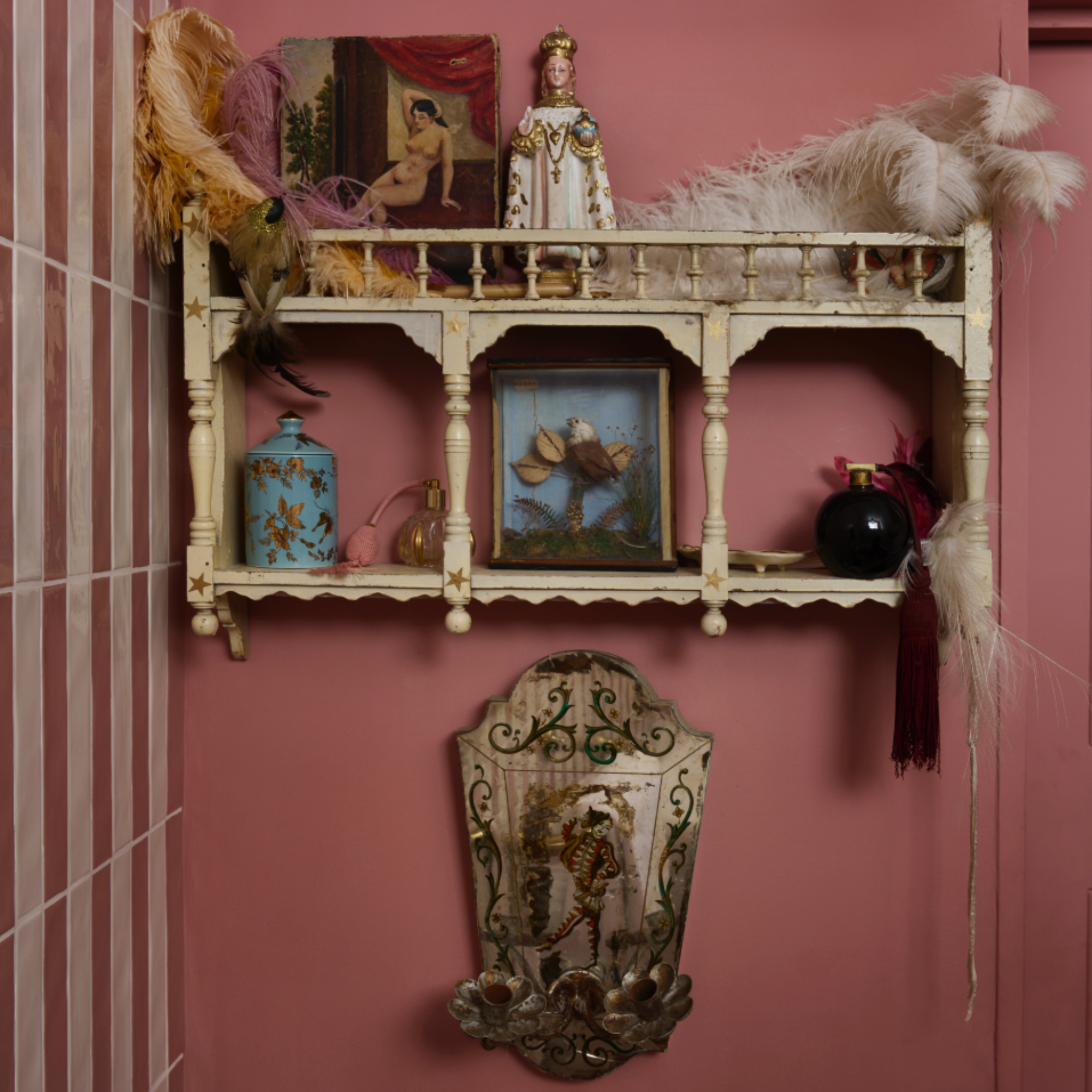 Pearl Lowe's bathroom with pink walls, pink and white tiles, vintage shelf and antique mirror
