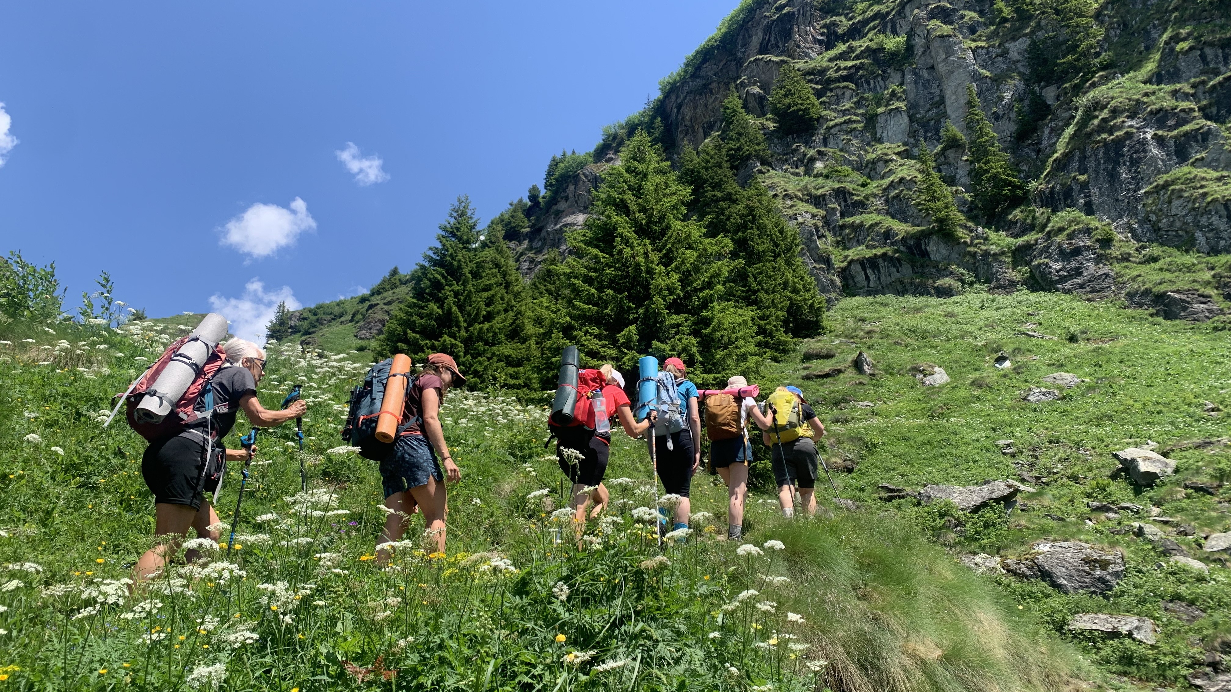 Women hiking to Cabane de Louvie with yoga mats on their backpacks
